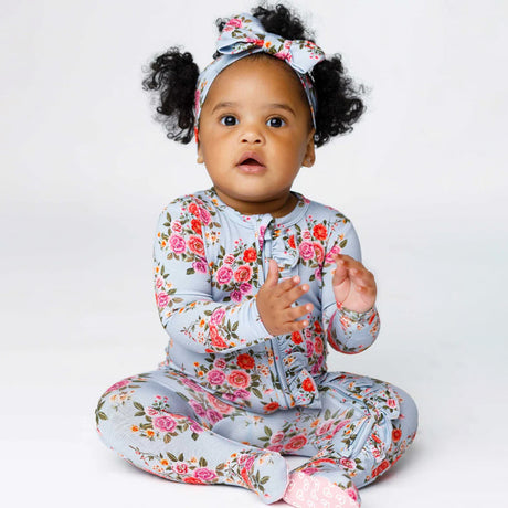 Baby wearing a floral outfit with a white background