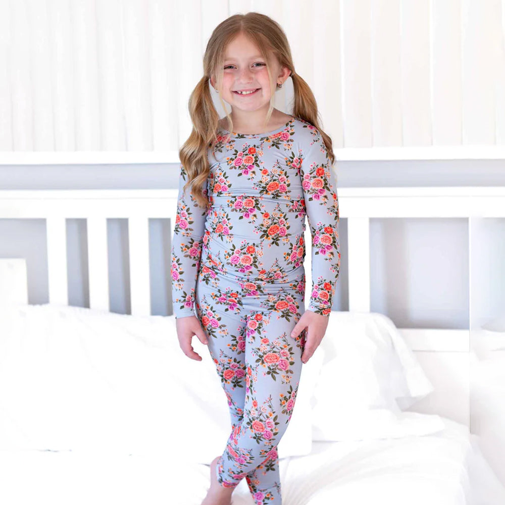 Young girl wearing a floral pajama set in a bedroom setting