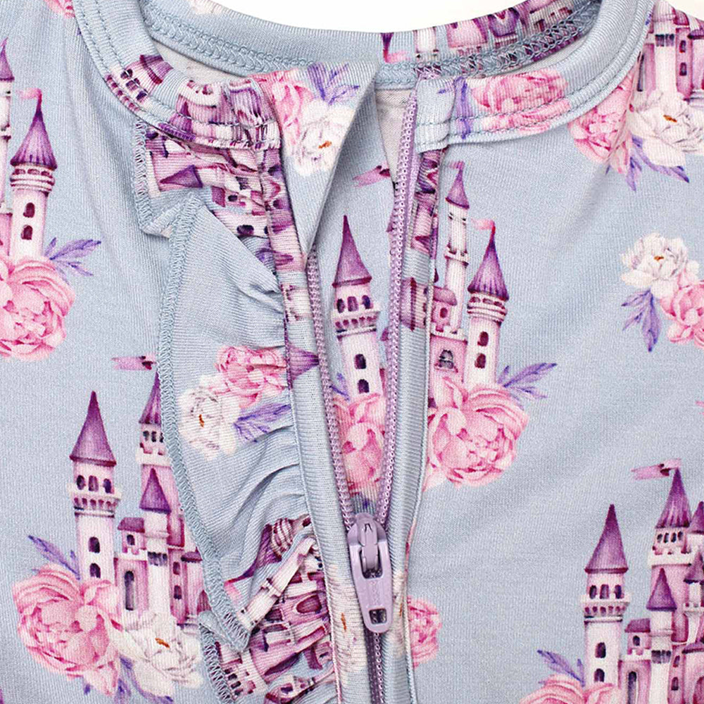 Children's outfit with castle and floral pattern on a light blue background
