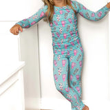 Child wearing a blue pajama set with pink and white patterns on a white background