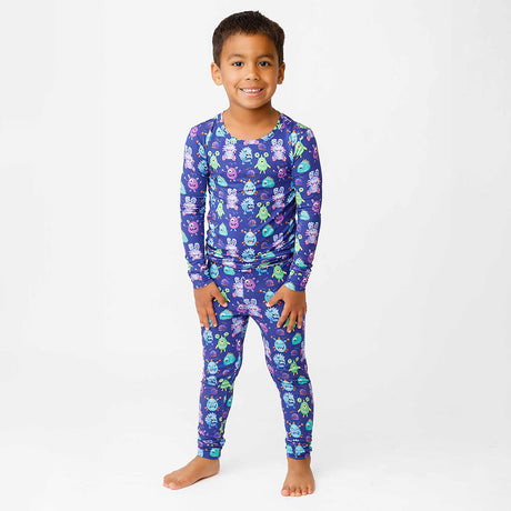 Child wearing a purple pajama set with cartoon characters on a white background