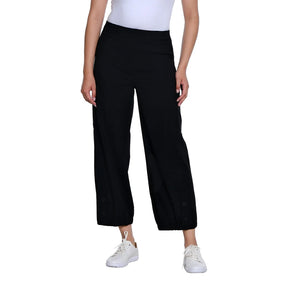 A model wearing black wide-leg cropped pants with white sneakers and a white top, shown from the waist down on a solid white background.