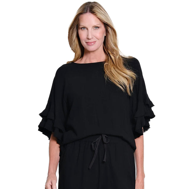 Woman wearing a black outfit with ruffled sleeves on a white background