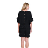 Woman wearing a black outfit with ruffled sleeves on a white background