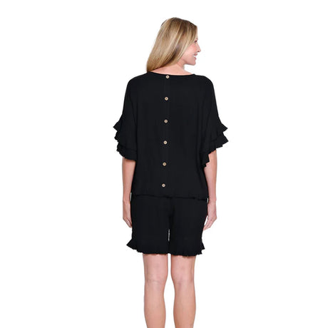 Woman wearing a black outfit with ruffled sleeves on a white background