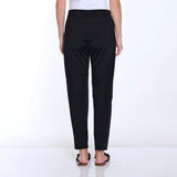 Black pants worn by a person on a white background