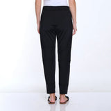 Black pants worn by a person on a white background