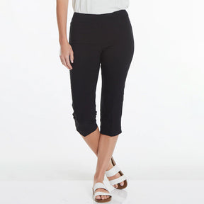 Person wearing black capri pants on a white background