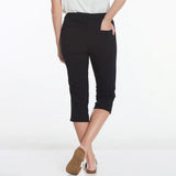 Person wearing black capri pants on a white background