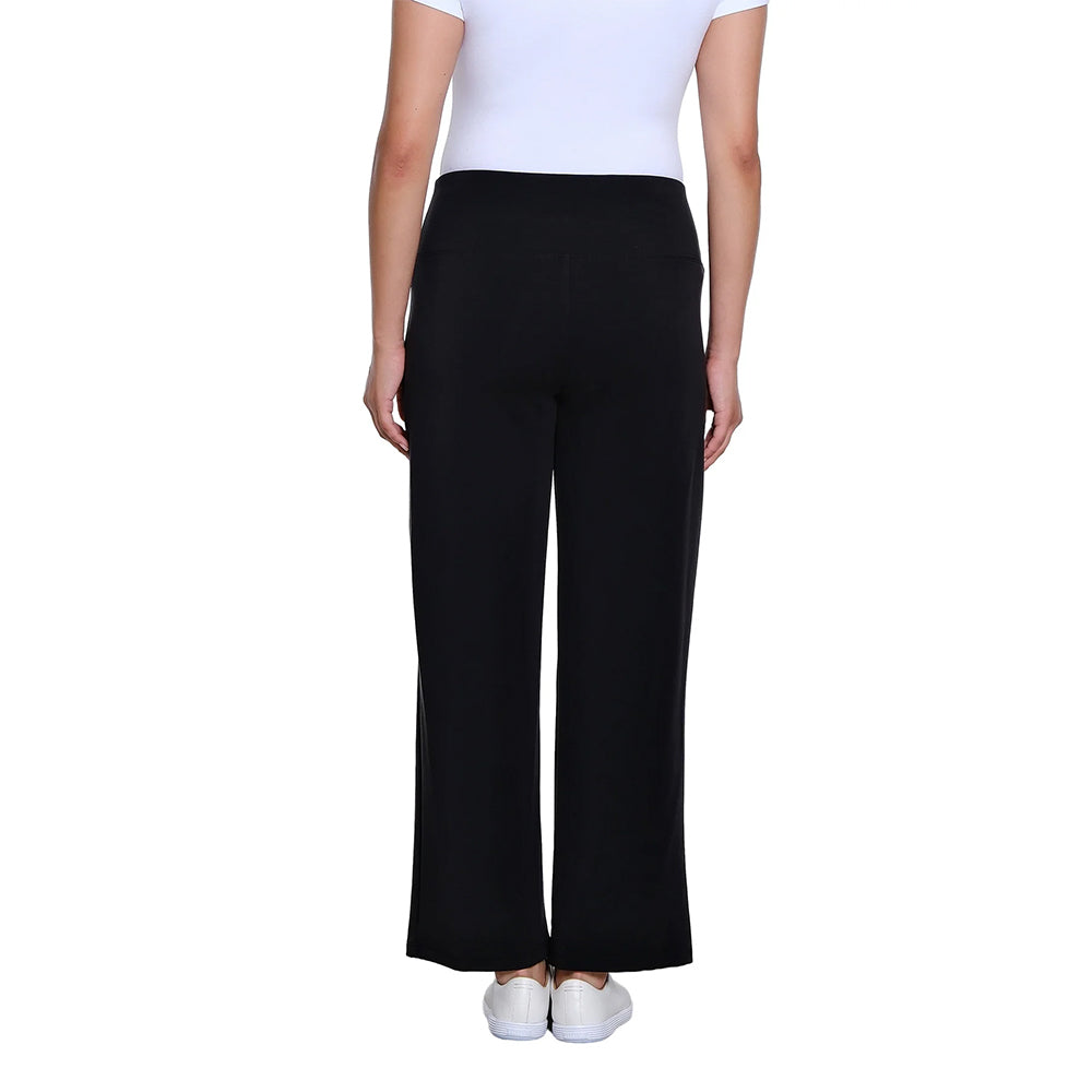 A model shown from the back wearing black wide-leg trousers, a white top, and white sneakers against a plain white background.
