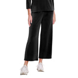 Person wearing black wide-leg pants and white sneakers on a white background