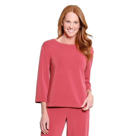 A woman with red hair is shown wearing a matching dusty rose pink lounge set, consisting of a long-sleeve top and pants, against a plain white background.