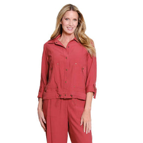 A woman modeling a matching red two-piece jumpsuit set, featuring a long-sleeve button-up shirt and coordinating pants, against a plain white background.