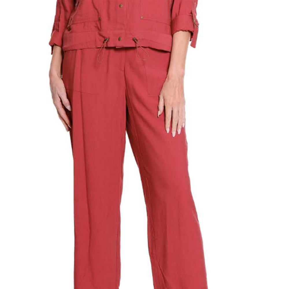 A model wearing a dusty red two-piece linen set consisting of a cropped jacket with rolled sleeves and matching wide-leg trousers, shown against a plain white background.