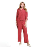 A model wearing a dusty red two-piece linen set consisting of a cropped jacket with rolled sleeves and matching wide-leg trousers, shown against a plain white background.