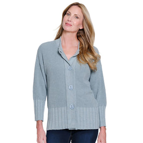 Woman wearing a light blue button-up cardigan on a white background
