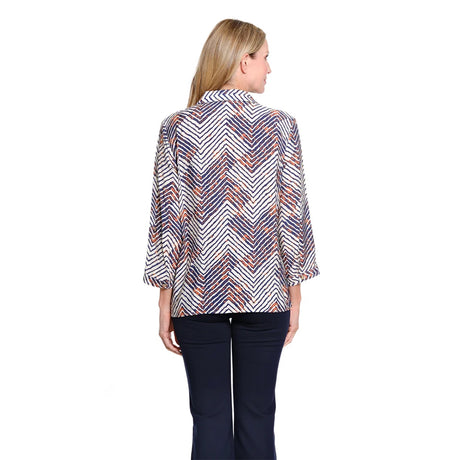 A woman viewed from the back wearing a long-sleeve collared blouse with a white, navy, and orange chevron pattern, paired with dark navy pants, against a plain white background.