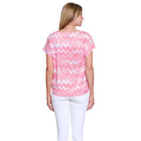 Woman wearing a pink and white zigzag patterned shirt on a white background
