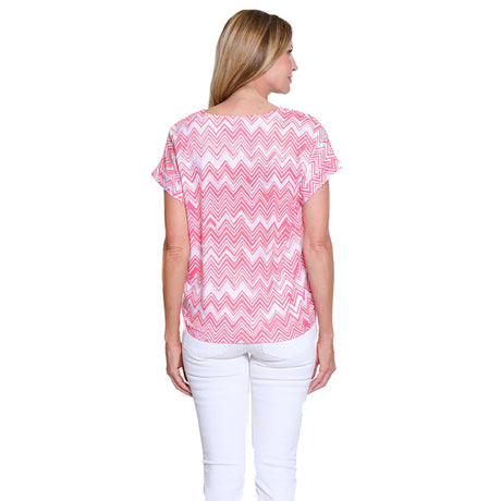 Woman wearing a pink and white zigzag patterned shirt on a white background
