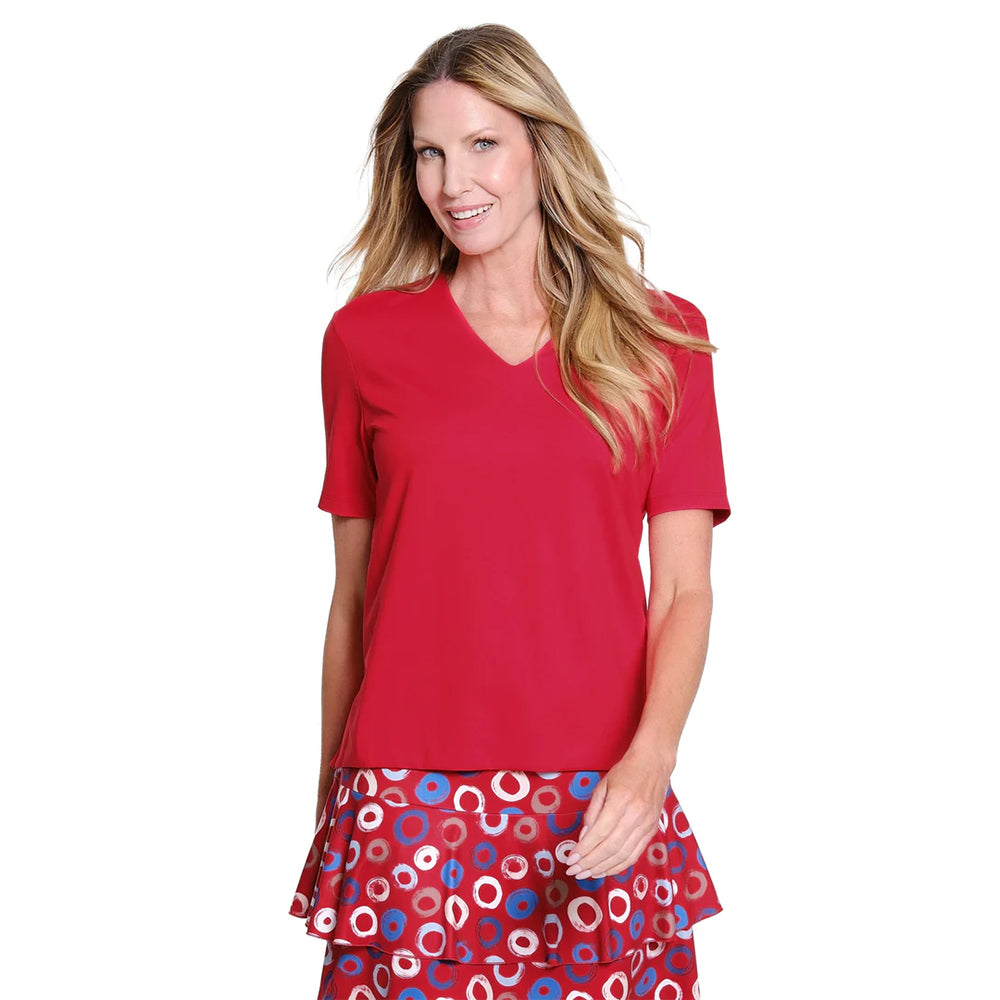 Woman wearing a red top and patterned skirt on a white background