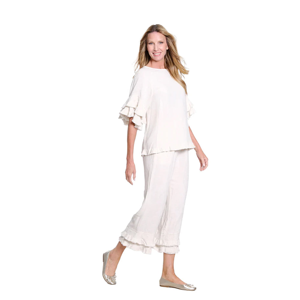 Woman wearing a white equestrian top and pants on a white background