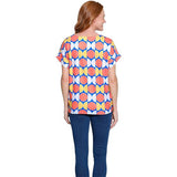 Woman wearing a colorful geometric patterned top on a white background