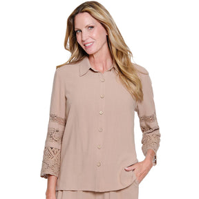 Woman wearing a beige blouse with lace sleeves on a white background
