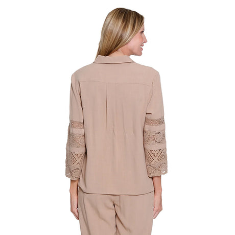 Woman wearing a beige blouse with lace sleeves on a white background