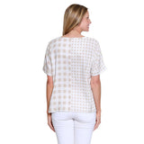 Woman wearing a checkered blouse and white pants on a white background