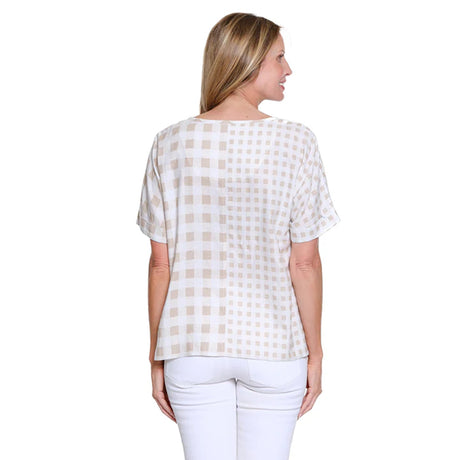 Woman wearing a checkered blouse and white pants on a white background