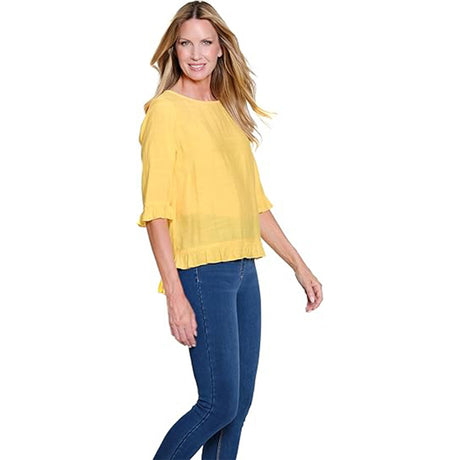 Woman wearing a yellow top and blue jeans on a white background