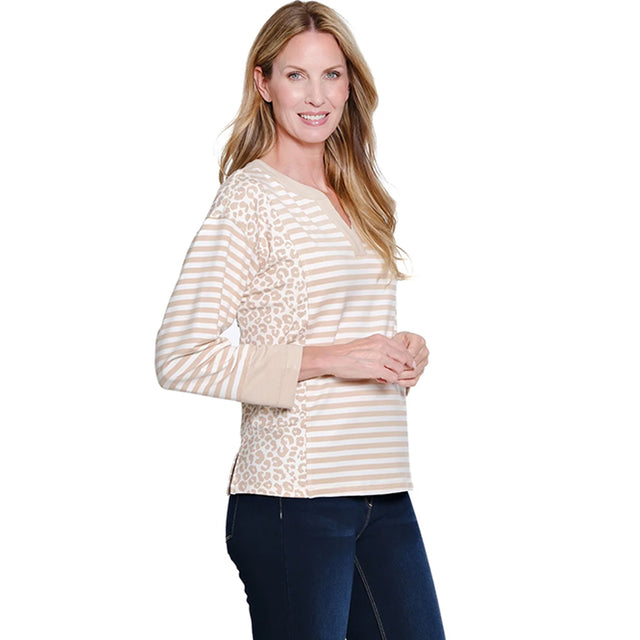 Woman wearing a cream and beige striped long-sleeve top with a leopard print accent on a white background