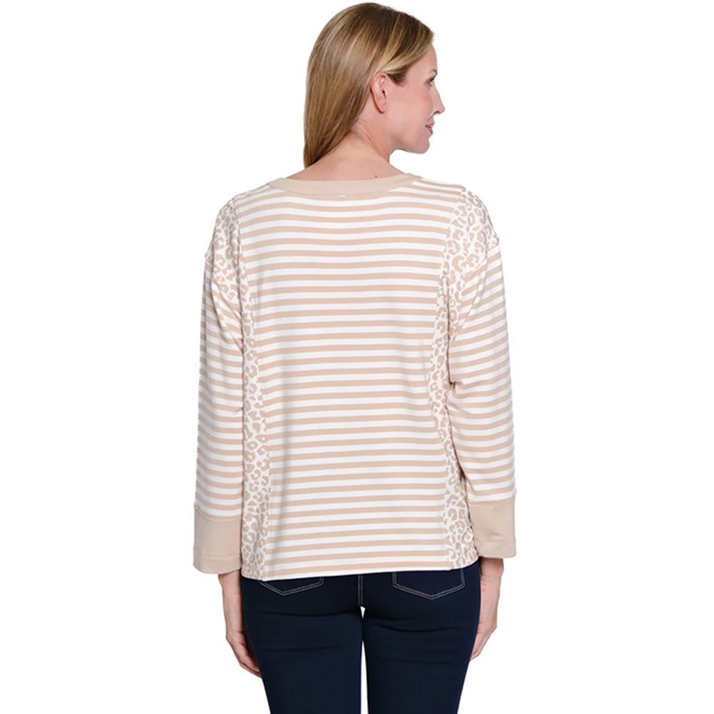 Woman wearing a beige and white striped shirt with ruffle details on a white background