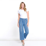 Woman wearing a white t-shirt and blue jeans with white stripes on a white background
