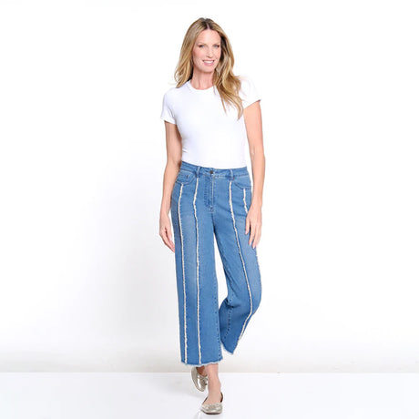Woman wearing a white t-shirt and blue jeans with white stripes on a white background
