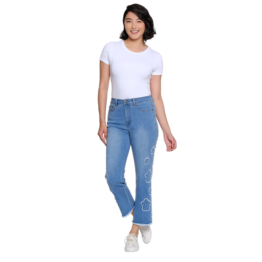 Woman wearing blue jeans with floral designs on a white background