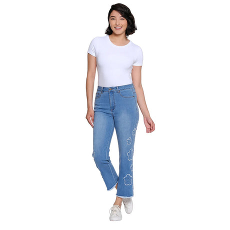 Woman wearing blue jeans with floral designs on a white background