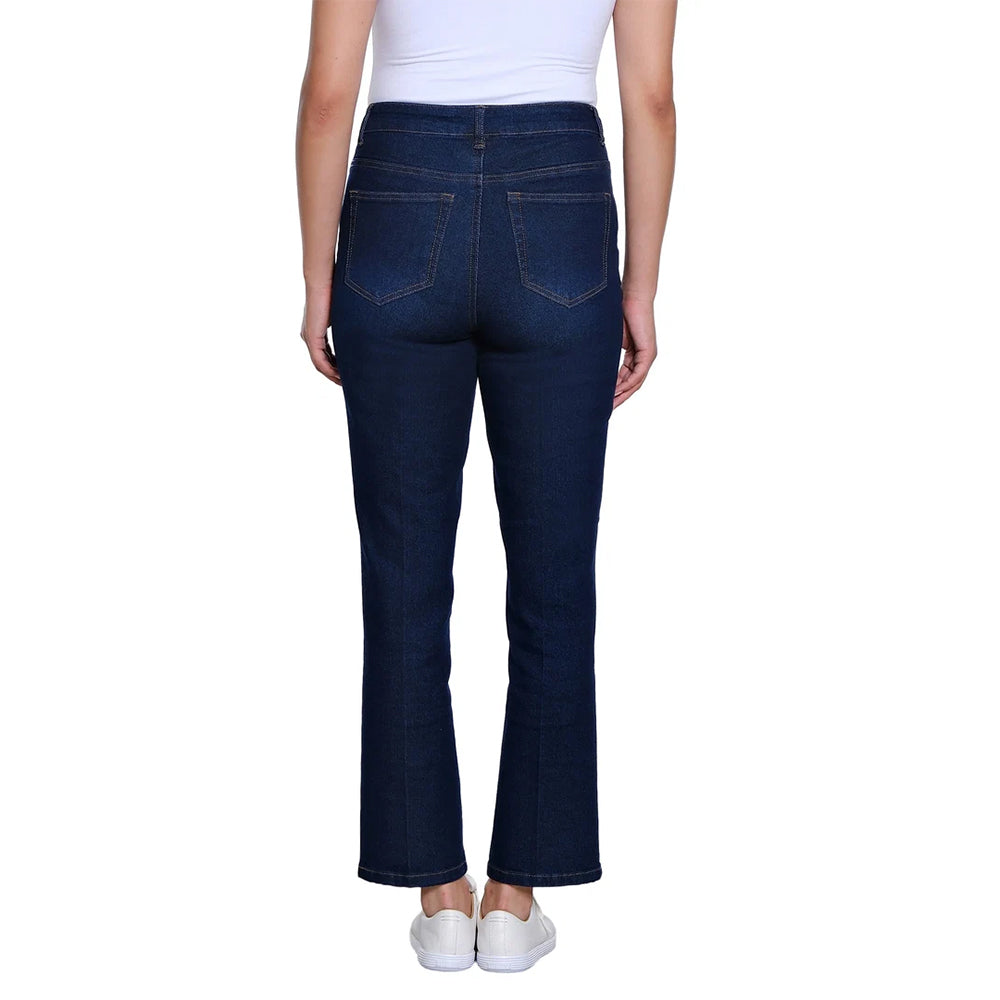 Rear view of a person wearing dark blue flare jeans with a white top and white sneakers against a plain white background.