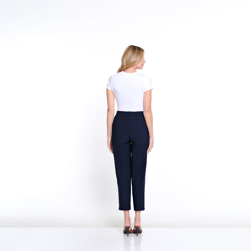 Woman wearing a white top and navy pants on a white background