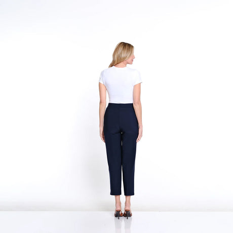 Woman wearing a white top and navy pants on a white background