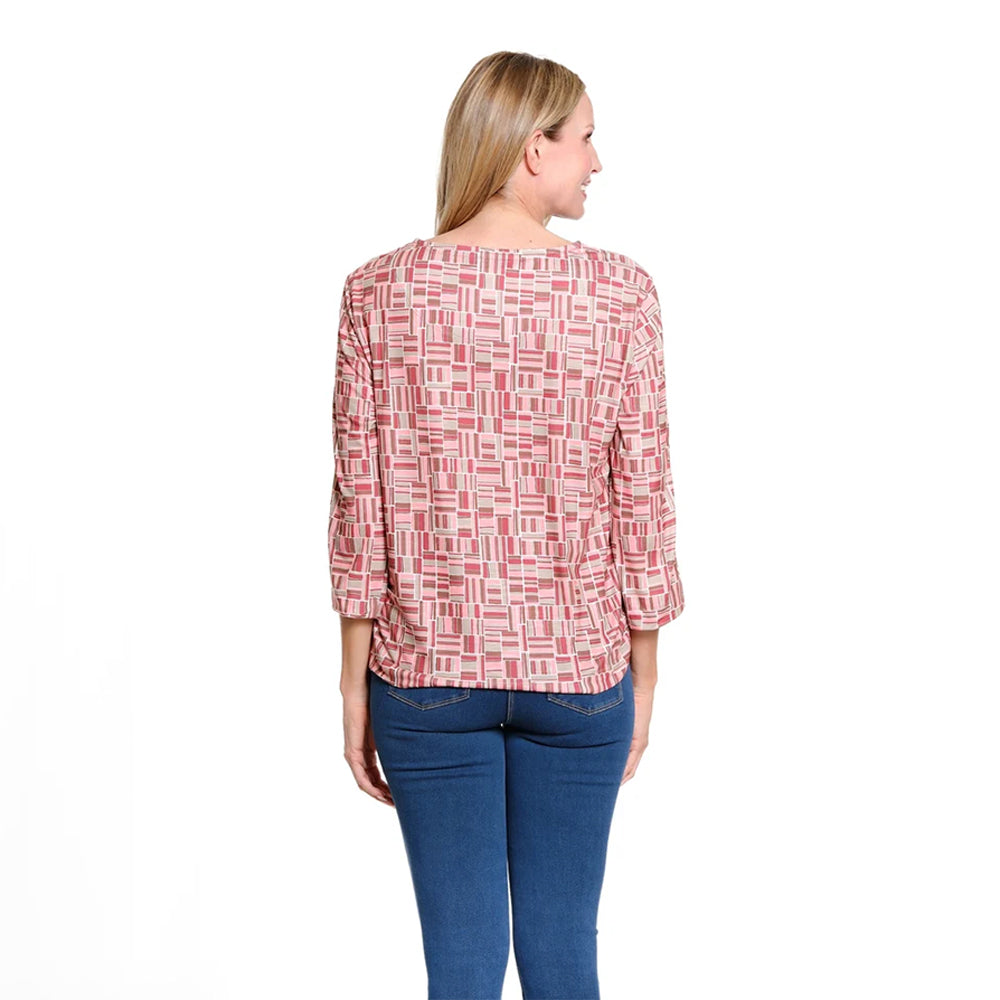 A woman shown from the back wearing a pink and white geometric patterned top with three-quarter sleeves, paired with blue jeans, against a plain white background.