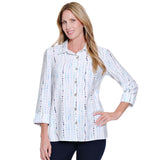 Woman wearing a white blouse with colorful patterns on a white background