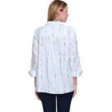 Woman wearing a white blouse with black and blue pattern on a white background
