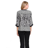 A woman modeling a black and white zebra-print button-up blouse with leopard-print patterned cuffs and hem, paired with black pants, against a plain white background.