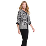 A woman modeling a black and white zebra-print blouse with three-quarter sleeves and black pants against a plain white background.