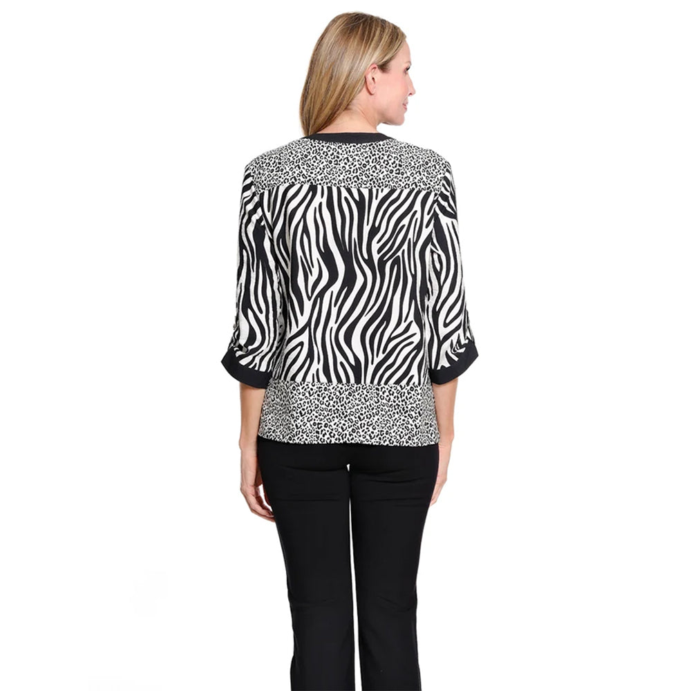 A woman shown from the back wearing a black and white zebra-print blouse with leopard-print trim and black pants, against a plain white background.