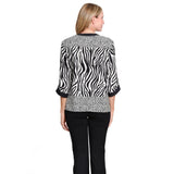 A woman shown from the back wearing a black and white zebra-print blouse with leopard-print trim and black pants, against a plain white background.