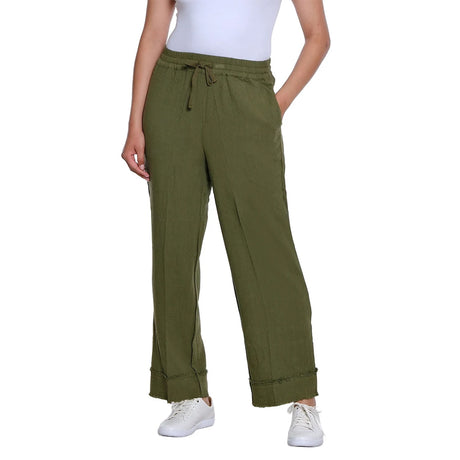A person wearing olive green wide-leg drawstring pants with a white top and white sneakers, shown against a plain white studio background.