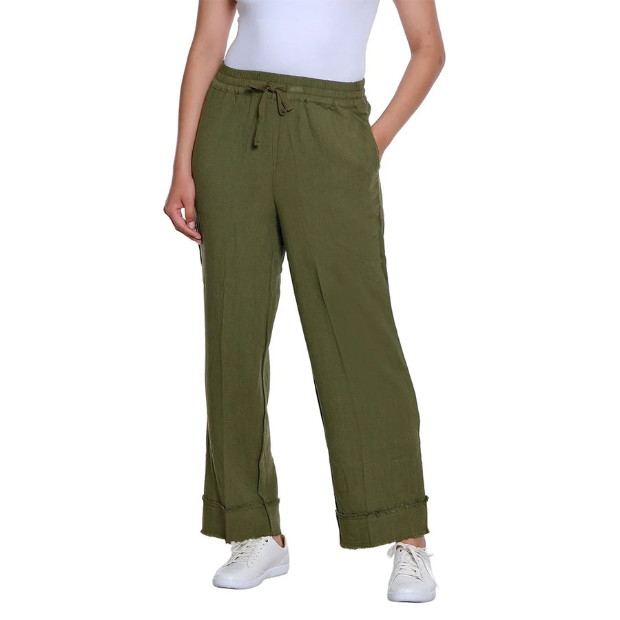 A person wearing olive green wide-leg drawstring pants with a white top and white sneakers, shown against a plain white studio background.