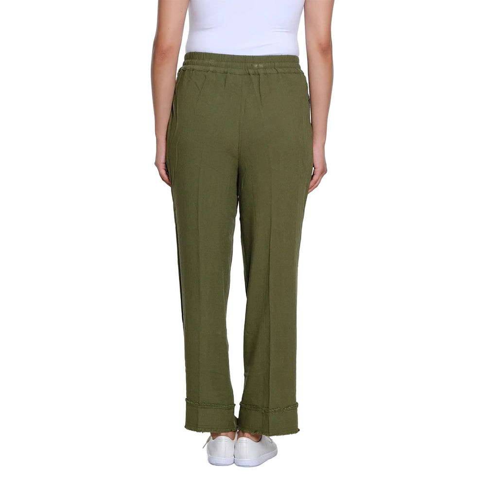 A model from the waist down wearing olive green wide-leg trousers with rolled cuffs, paired with a white top and white sneakers, against a plain white background.